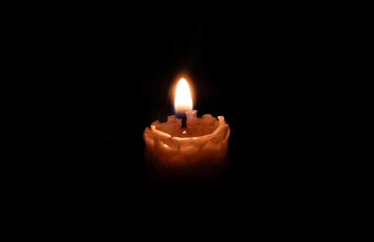 A single lit candle in a dark room, creating a warm ambiance.