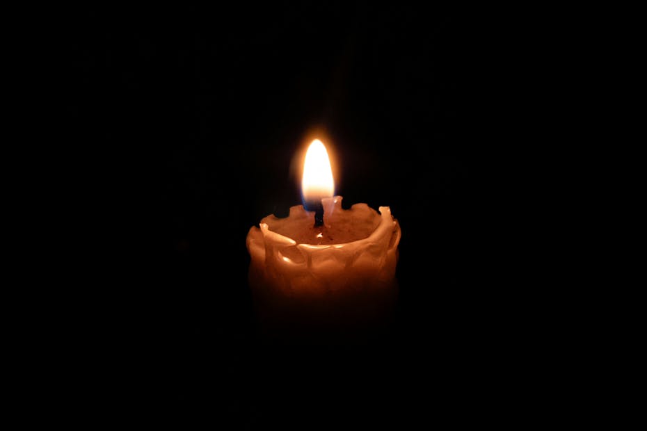 A single lit candle in a dark room, creating a warm ambiance.