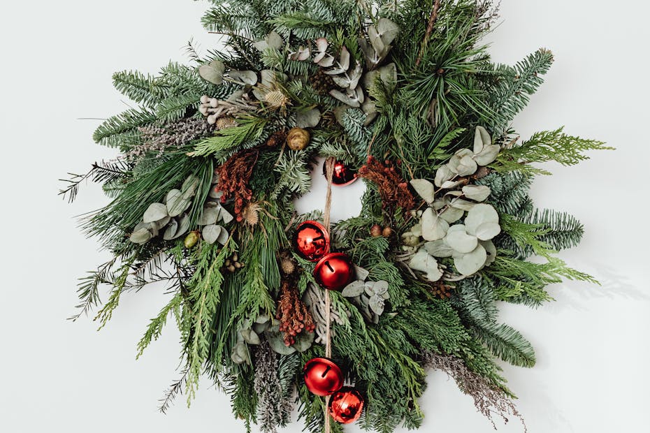 A beautiful Christmas wreath adorned with red bells on a white background.